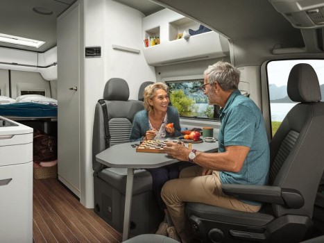 Frau & Mann sitzen am Tisch im Innenraum und Frühstücken